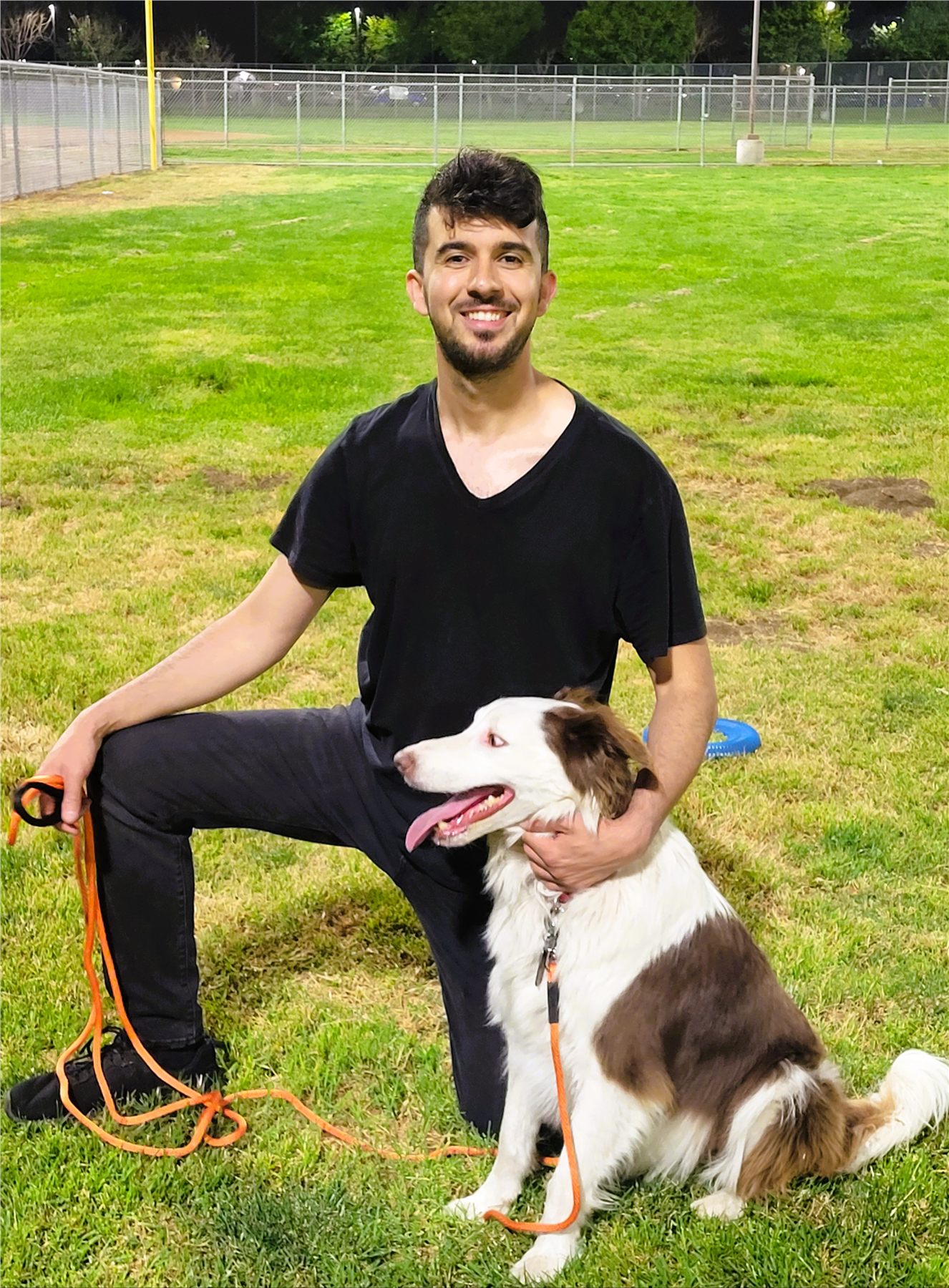 Ali smiling with a dog during an outdoor training session